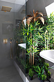 Golden palm tree, bamboo and artificial plants in luxury bathroom