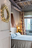 Double bed in bedroom with festive wreath on door