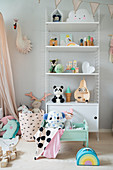 Cute children's accessories on shelves in girl's bedroom in pastel shades