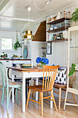 Spoke-back bench and various chairs around table in kitchen-dining room