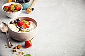 Oat granola with fresh berries, banana, yogurt, chia seeds and mint leaves