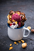 Bubble waffle (chocolate vanilla) with ice cream, soy cream, spelt pretzels, cornflakes and chocolate decorations (vegan)