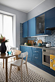 Runder Esstisch in der Wohnküche mit blauer Küchezeile