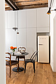 White retro fridge in niche in floor-to-ceiling fitted cupboards