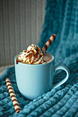 Hot chocolate with whipped cream, toffee sauce and biscuits