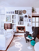 Sofa and wing-back chair in front of fireplace in festively decorated white living room