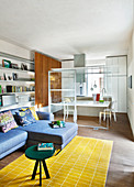 Open-plan interior with half-height glass partition between living and dining areas