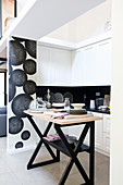 Moderne schwarz-weiße Küche hinter Abtrennung in Loft-Wohnung
