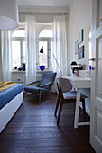 View into bedroom decorated in white and blue in period apartment