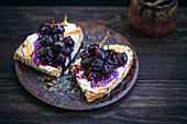 Toasted rye bread topped with ricotta cheese, roasted red grapes and honey