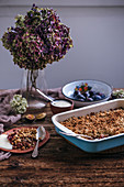 Plum crumble in a baking pan and served on a ceramic plate