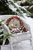 Kleines Weihnachts-Arrangement auf Korbsessel im Schnee