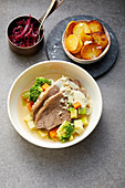 Boiled beef with horseradish sauce on a bed of root vegetables
