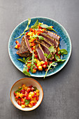 Tuna fish fillet in a chia seed crust on a rocket and mango salad