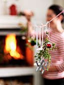 Christmas decorations hanging from cord in front of fireplace