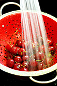 Cherries being washed in a colander