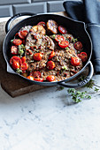 Beef steaks with an anchovy sauce, oregano and braised tomatoes