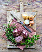 Two types of Grützwurst blood sausage on a wooden board
