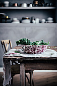 Fresh kale in a vintage enamel bowl on a rustic wooden table