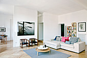 Pale sofa in modern open-plan interior with herringbone parquet floor