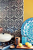 Tiled splashback with black-and-white pattern next to wall painted yellow