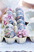 Decoupage floral eggs and purple flowers in egg box