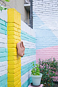Farbenfroh gestaltete Ziegelwände eines städtischen Innenhofgartens