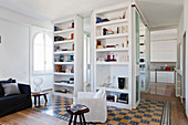 Floor-to-ceiling shelves used as partition element in open-plan interior