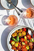 Tomatensalat aus bunten Kirschtomaten serviert mit Getränk