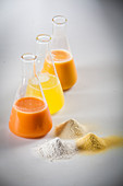 Chemistry bottle of juices and pyramids of food ingredients