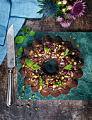 A wreath-shaped chocolate biscuit cake with pistachio nuts and cranberries