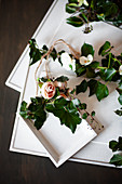 Ivy tendrils and fabric flowers arranged with framed pictures painted over in white