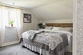 Romantisches Schlafzimmer mit gemusterten Tapeten, Häkeldecke auf Doppelbett