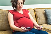 Pregnant woman testing blood sugar level in diabetes