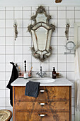 Antique Venetian mirror and sconce lamps above washstand