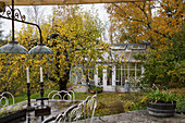 View of conservatory in autumnal garden seen from terrace