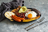 Bandeja paisa - Columbian fried pork belly, black pudding, sausage, arepa, beans, fried plantain, avocado egg, and rice