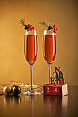 Zwei rote Cocktails mit Beeren und Rosmarin zu Weihnachten