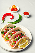 Homemade Mexican Tacos with fresh vegetables and chicken on white background