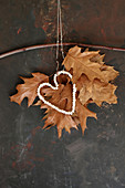 Autumnal arrangement of dried oak leaves with bead heart