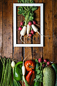 Flat lay of bunch of red and white radish in white frame and set of various fresh vegetables