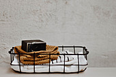 Cloths, knitted cloth and soap in small wire basket