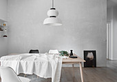 White tablecloth, carafe and eucalyptus branch on pale wooden table