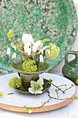 Springlike flower arrangement in green ceramic cups