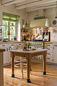 Wooden table with floor-protection socks in cosy country-house kitchen
