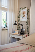 Plant climbing over picture above bedside table in rustic bedroom