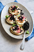 Blinis mit Ziegenkäse-Sahne, Räucherfisch und Kaviar