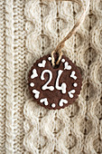 A chocolate biscuit with white writing icing on a knitted jumper