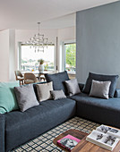 Blue corner sofa on geometric rug in seating area