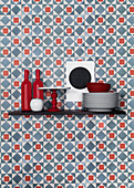 Küchenutensilien auf Regalbrett vor blau-roter Tapete mit grafischem Muster